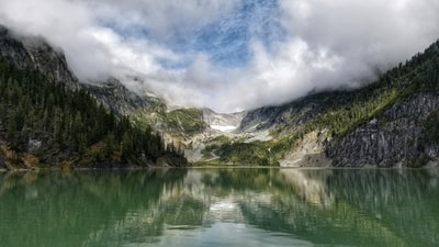 风景摄影的山包围着松树和身体的水
